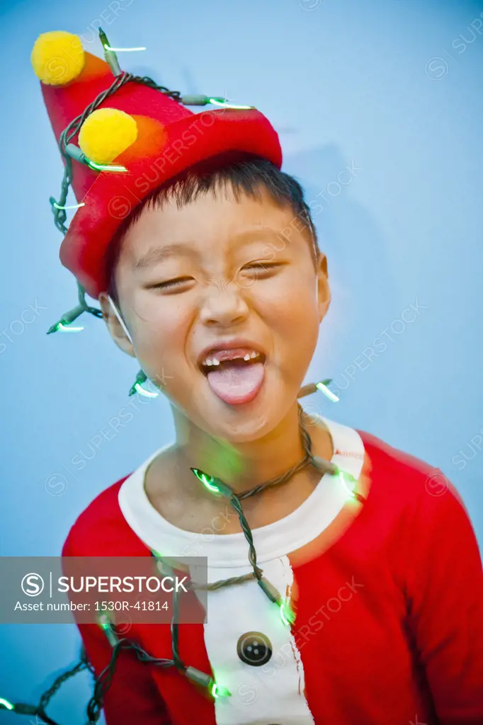 Boy in red costume with holiday lights,