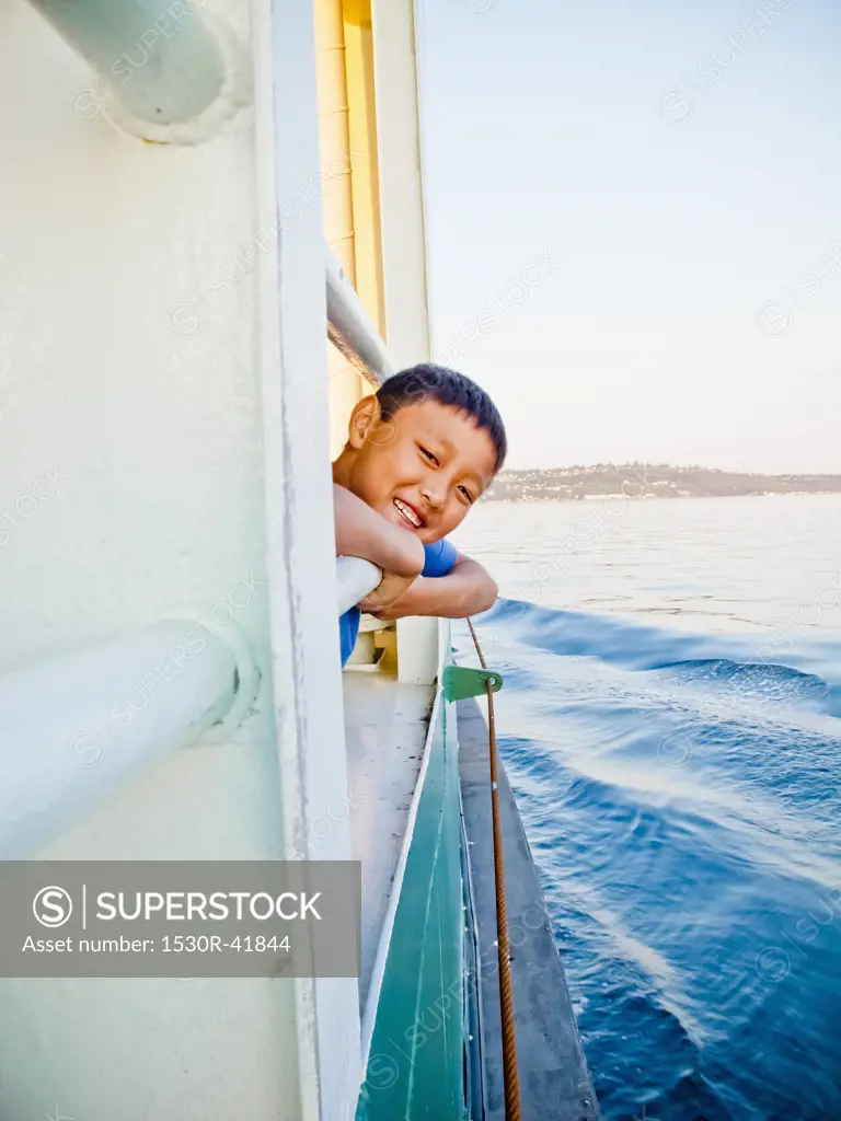 Young boy looking out ferry window,  Puget Sound, Washington, USA