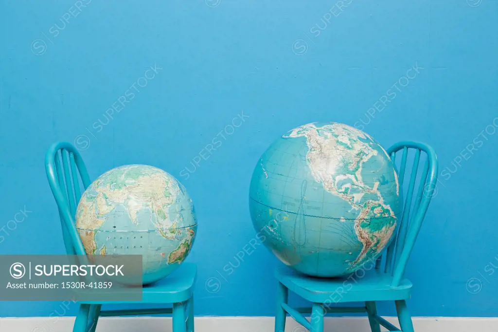 Two globes placed on two chairs facing each other,