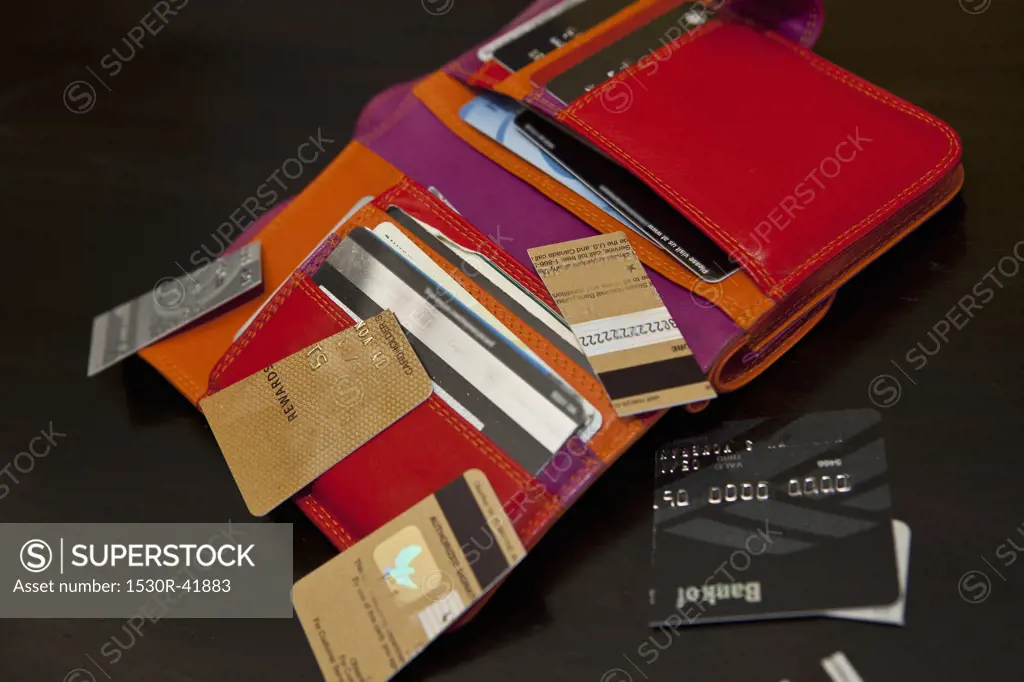 Open colorful wallet with cut up credit cards