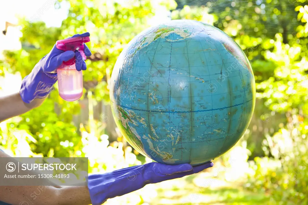 Woman wearing rubber gloves to clean globe outdoors