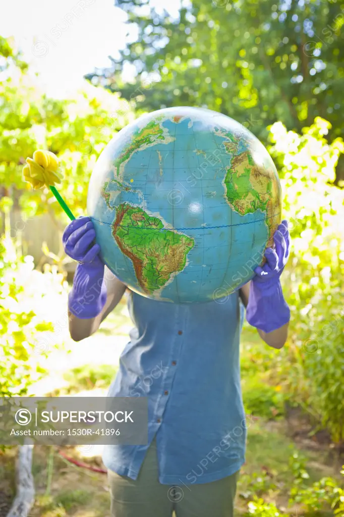 Woman wearing rubber gloves and holding globe