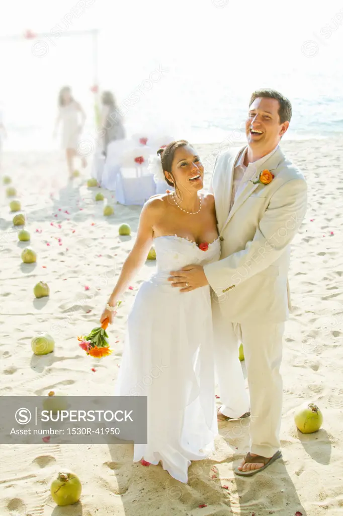 Bridal couple laughing on beach,  Sayulita, Mexico