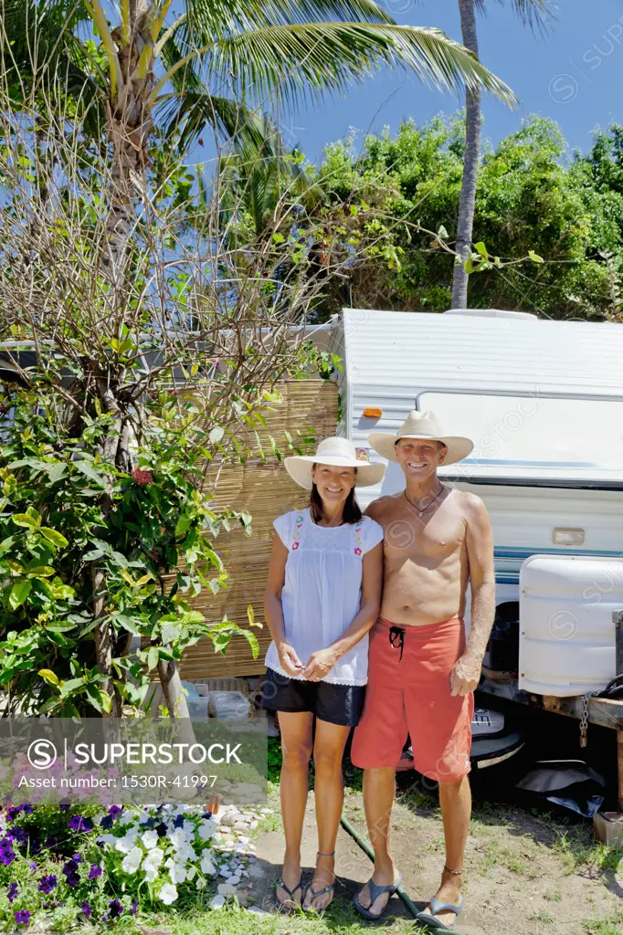 Man and woman standing in garden with camper,  Sayulita, Mexico