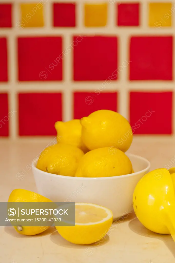 Bowl of lemons on counter with red tiles behind