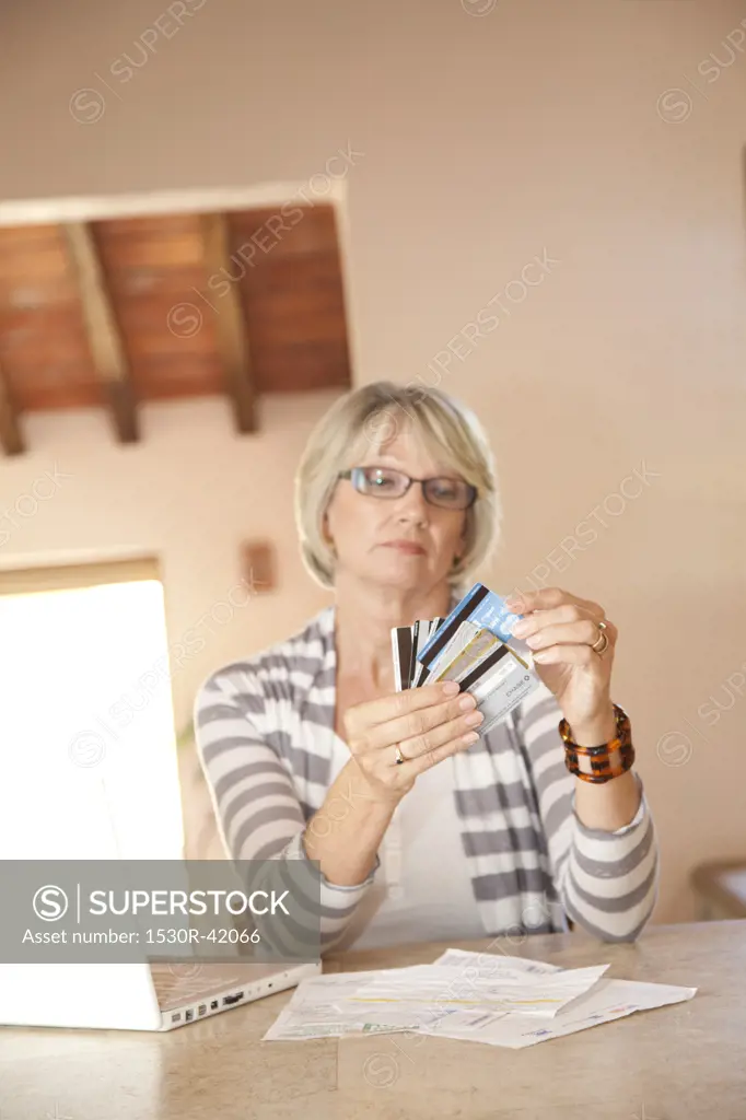 Woman at home office looking at credit cards