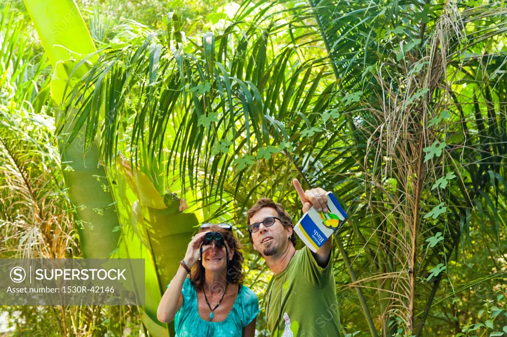 Man and woman bird watching in jungle