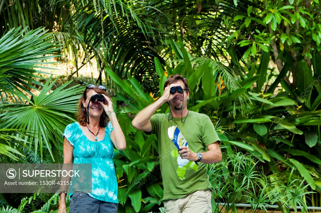 Man and woman bird watching in jungle
