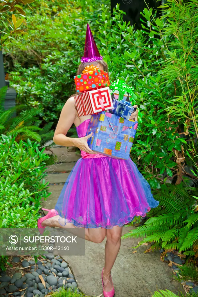 Woman in party clothes holding presents