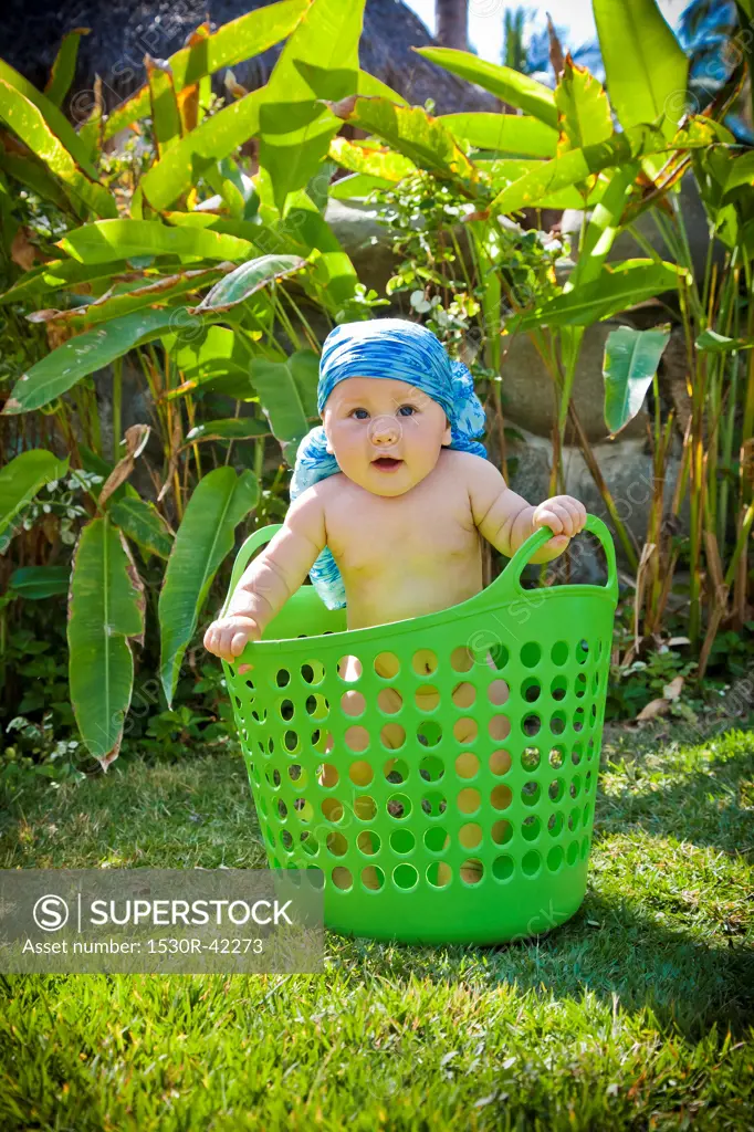 Baby boy in laundry basket outdoors