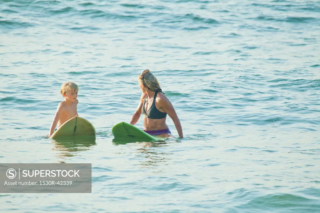 Woman and boy on surfboards in water