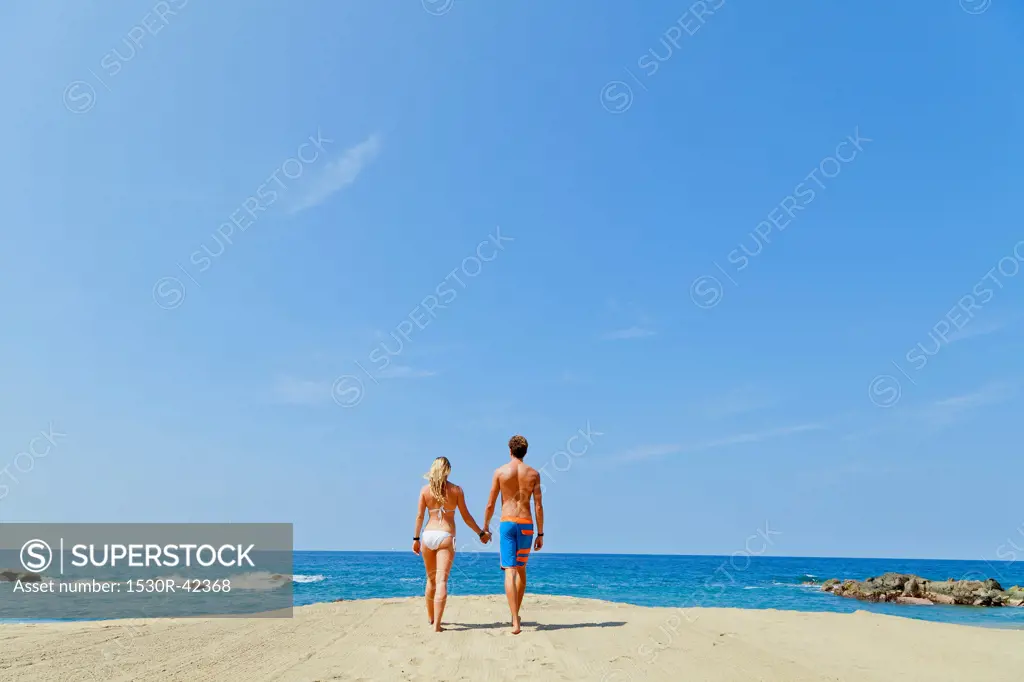 Young man and woman walking toward shore