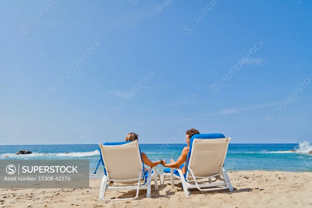Rear view of couple in beach chairs