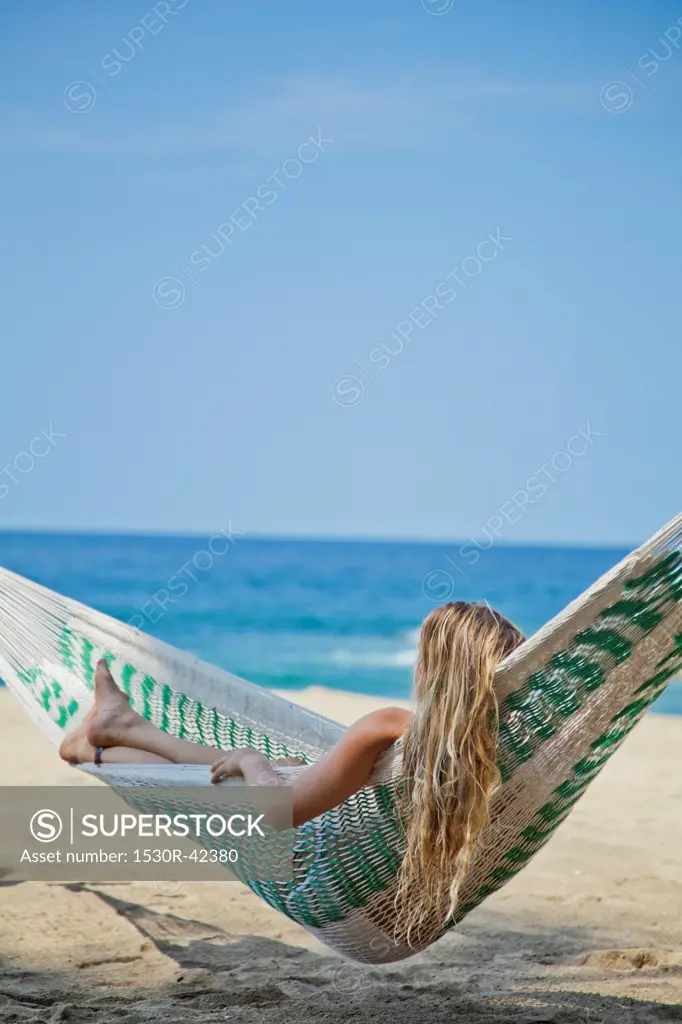Young woman in hammock on beach