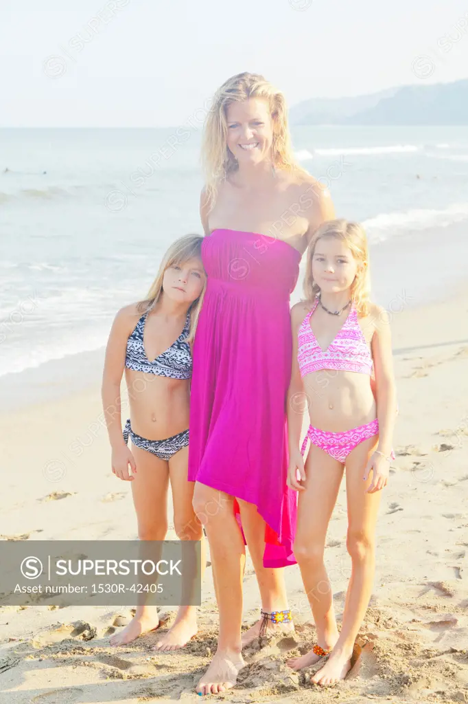 Woman with two girls standing on beach