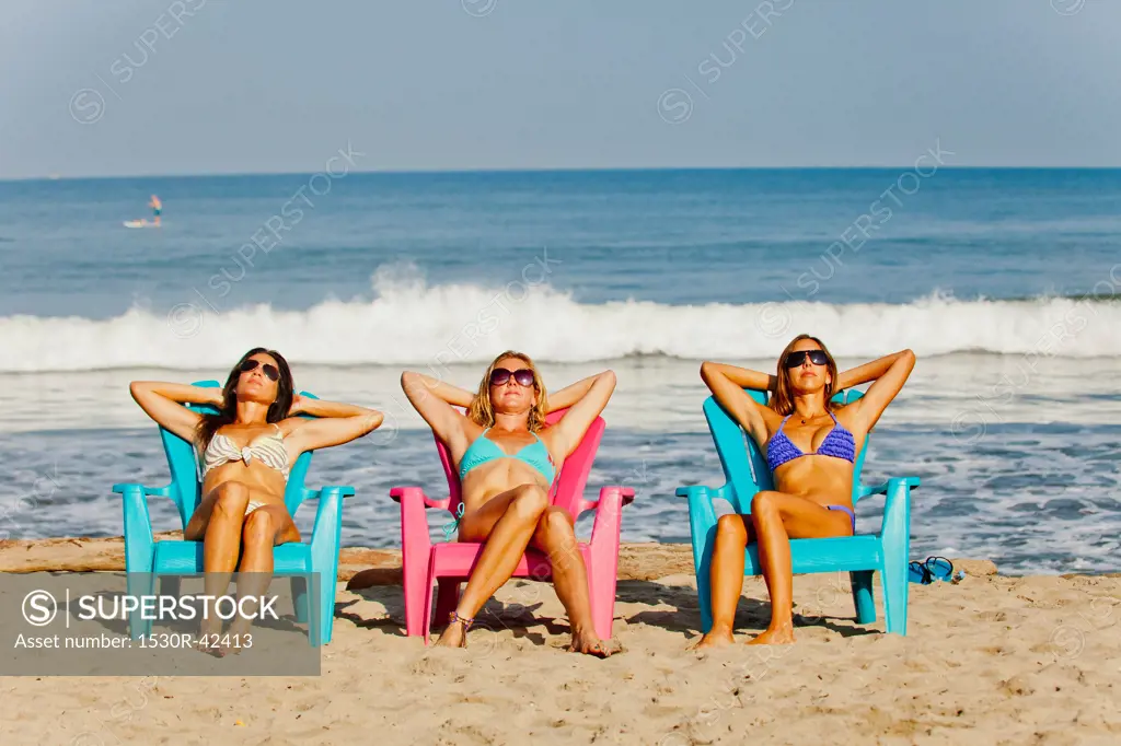 Three women lounging on beach chairs