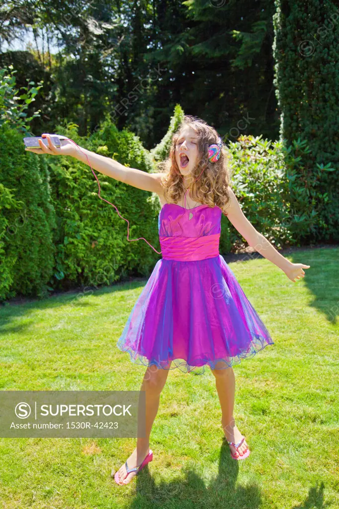 Teen girl in party dress singing outdoors