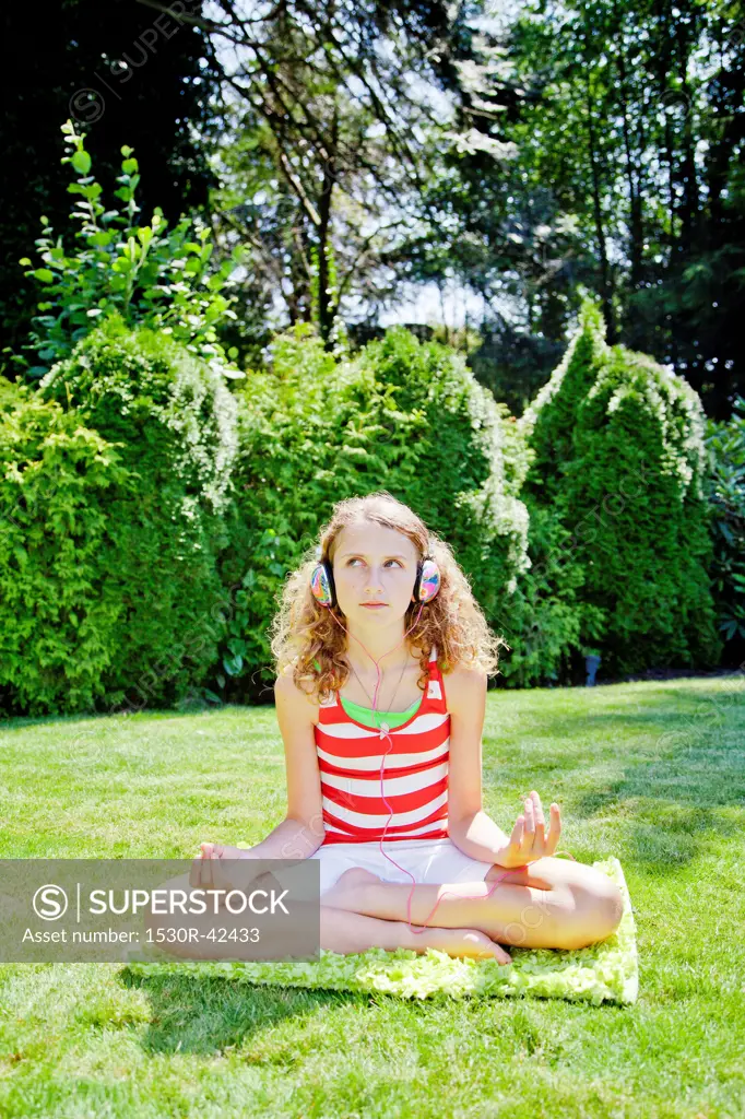 Teen girl meditating outdoors