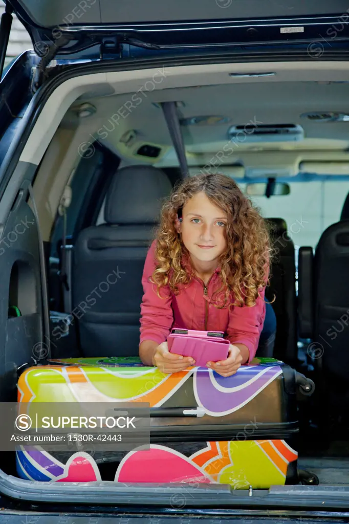 Teen girl with luggage in car