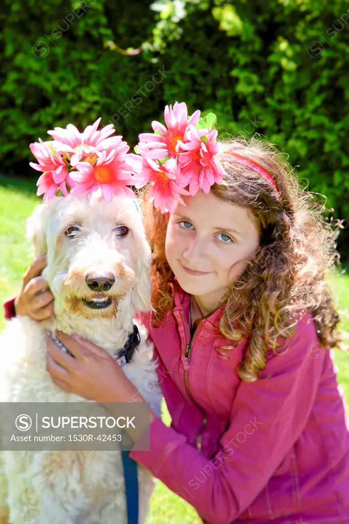 Teen girl and white dog wearing flowers