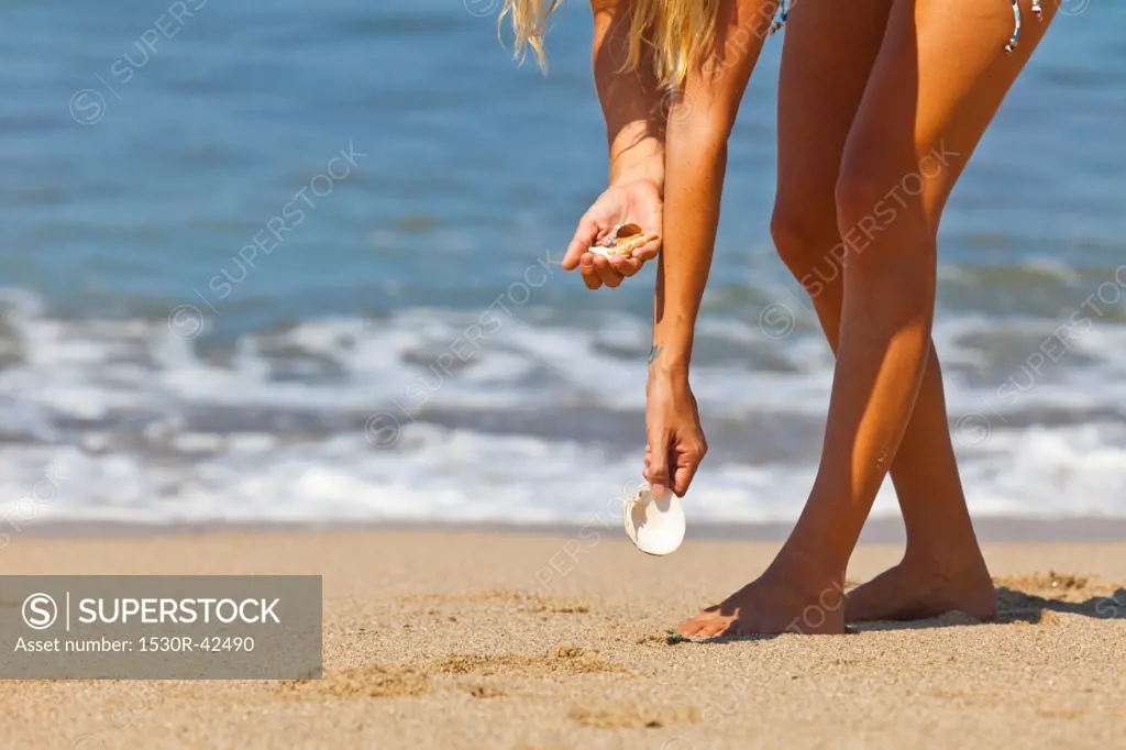Woman beachcombing for shells