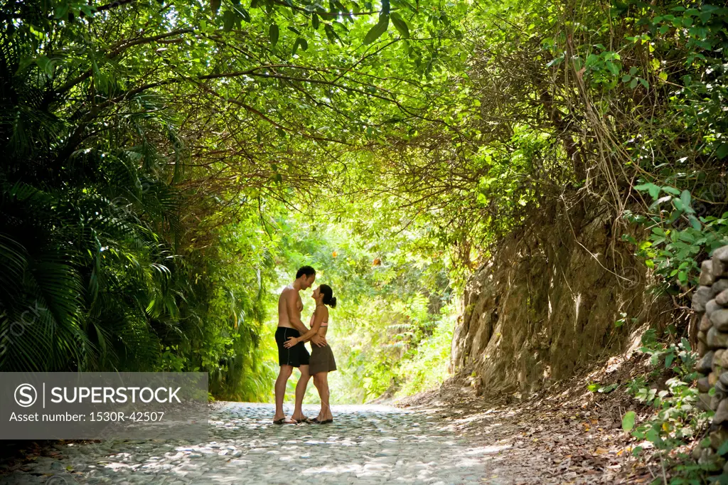 Couple walking down tree arched path