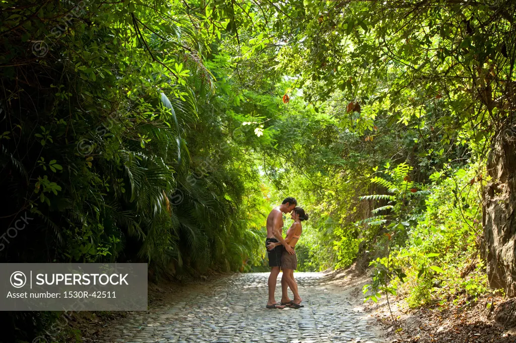 Couple walking down tree arched path