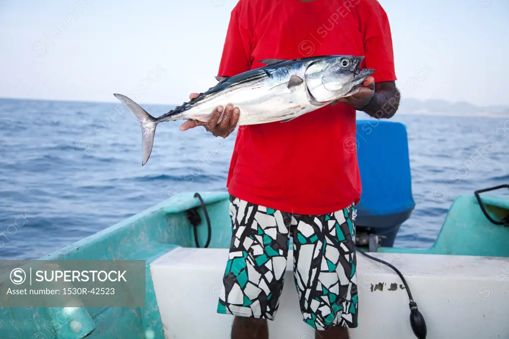 Man with fish on charter fishing boat