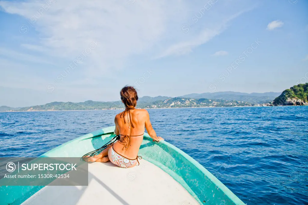 Woman sitting in bow of boat