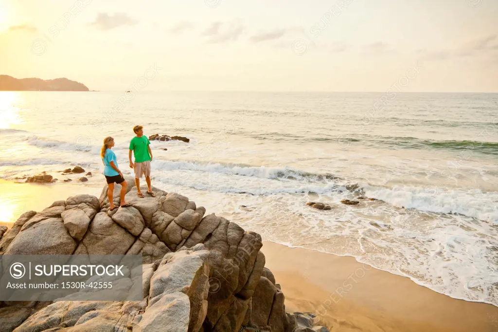 Couple hiking on beach rocks