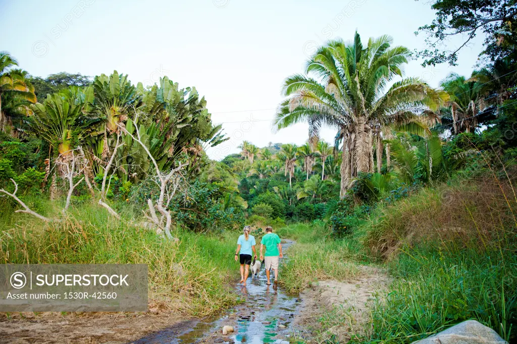 Couple hiking in jungle stream bed