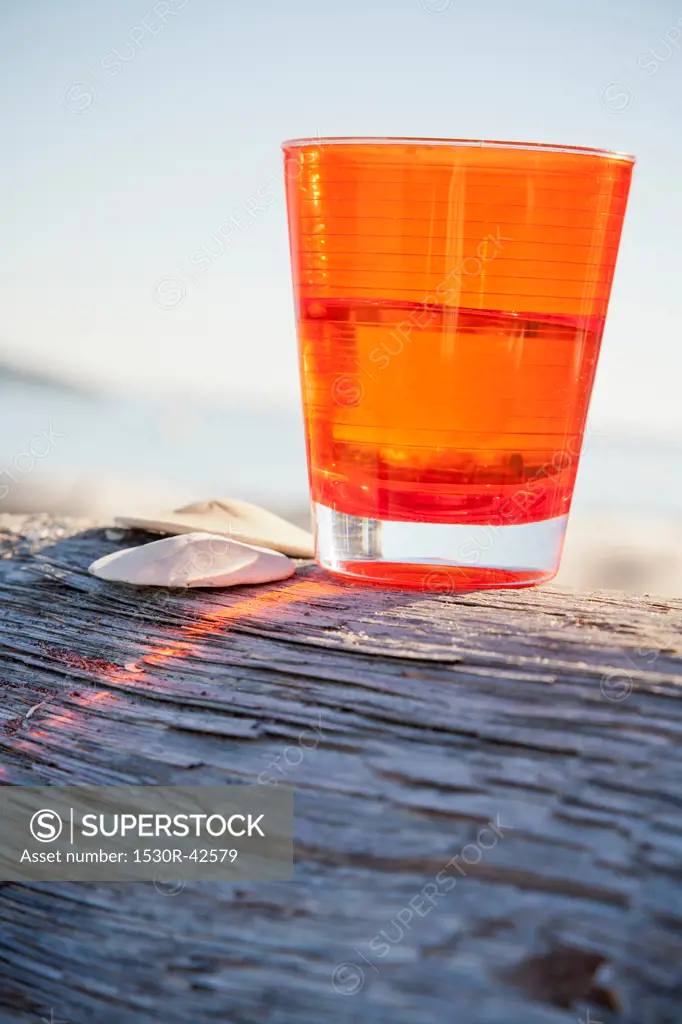 Orange cup on driftwood log