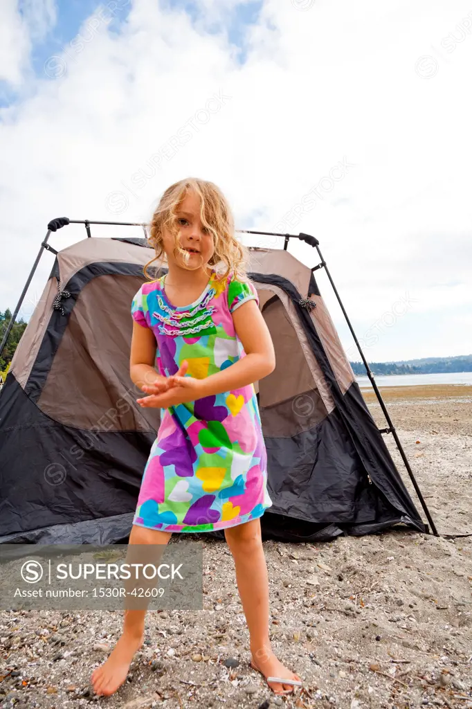 Young girl in front of tent on beach