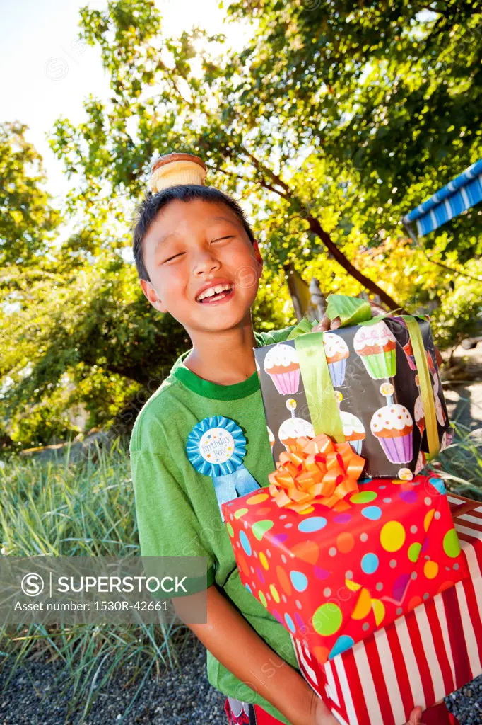 Young boy in birthday hat with presents