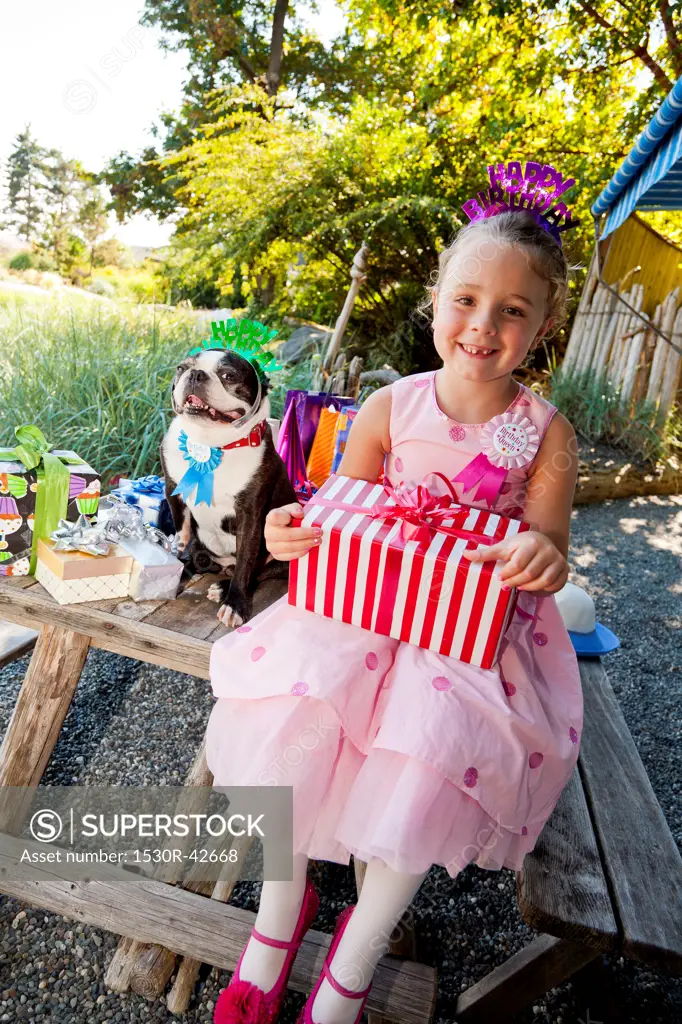 Young girl and dog at outdoor birthday paty