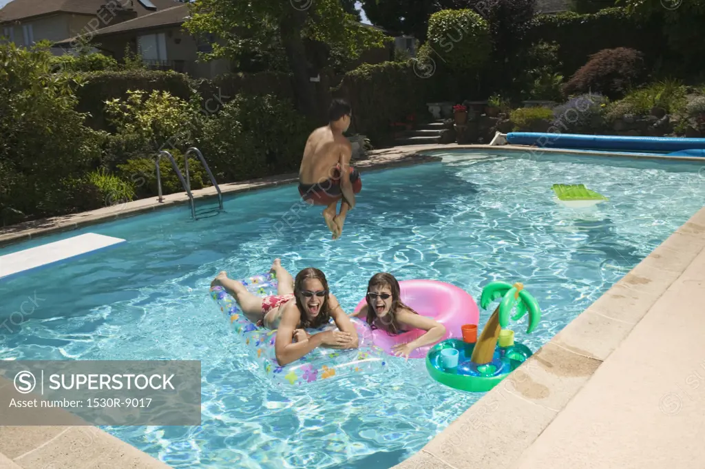 Teenagers playing in a swimming pool.