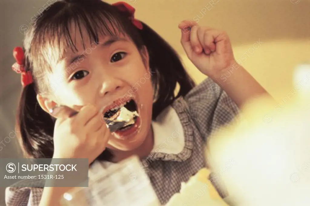 Portrait of a girl eating with a spoon
