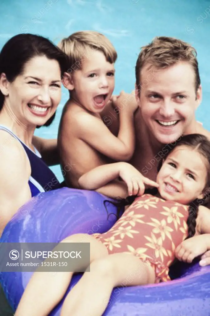 Portrait of a father and mother with their son and daughter in a swimming pool