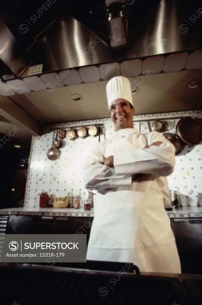 Chef standing in a kitchen with his arms folded