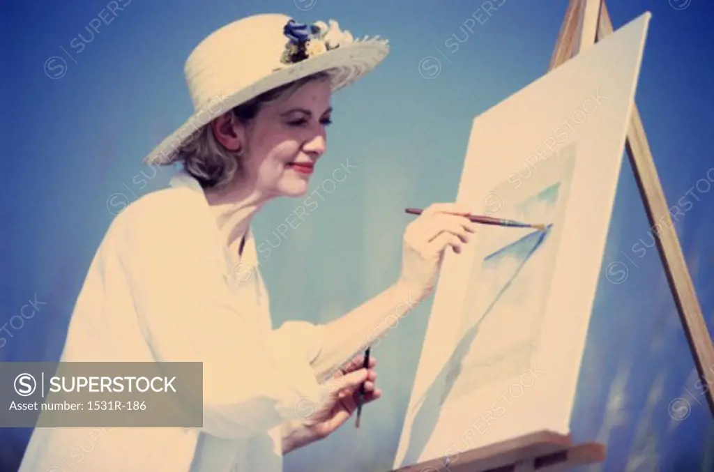 Mature woman painting on an easel