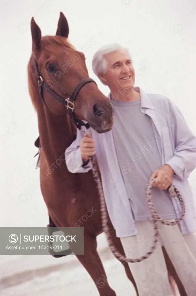 Senior man standing with a horse