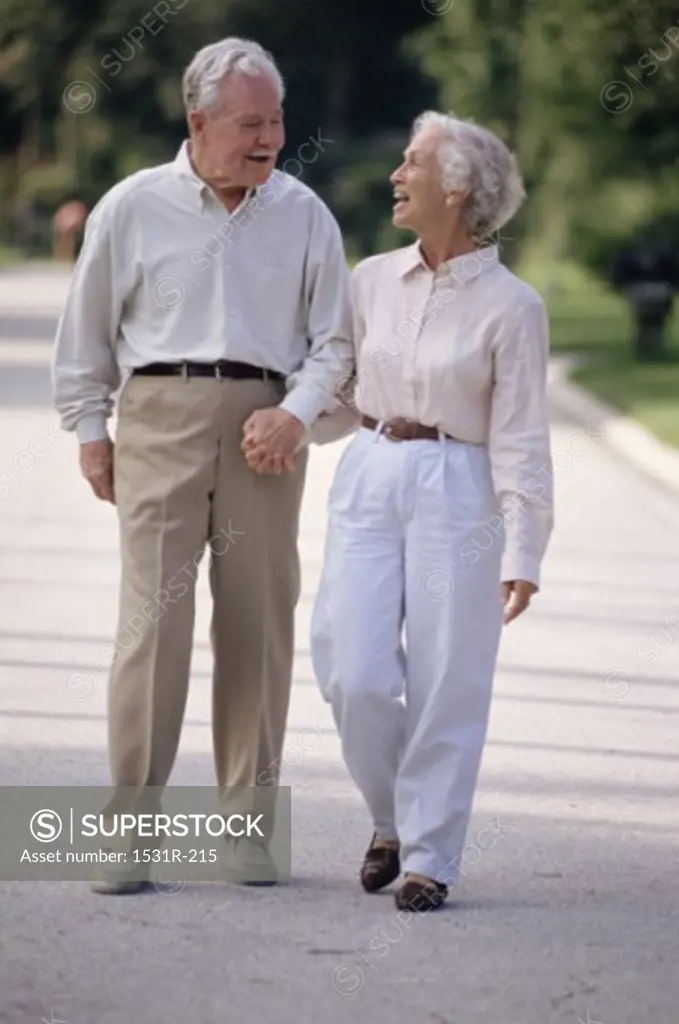 Senior couple walking outdoors holding hands