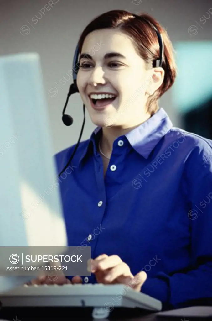 Customer service representative working on a computer smiling