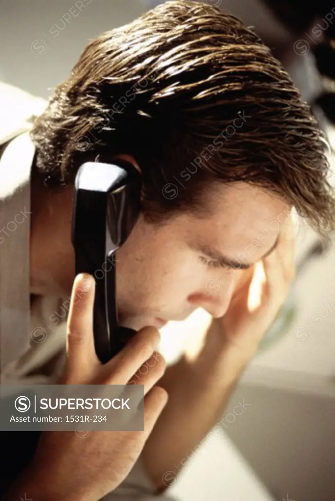 Close-up of a businessman talking on a landline telephone