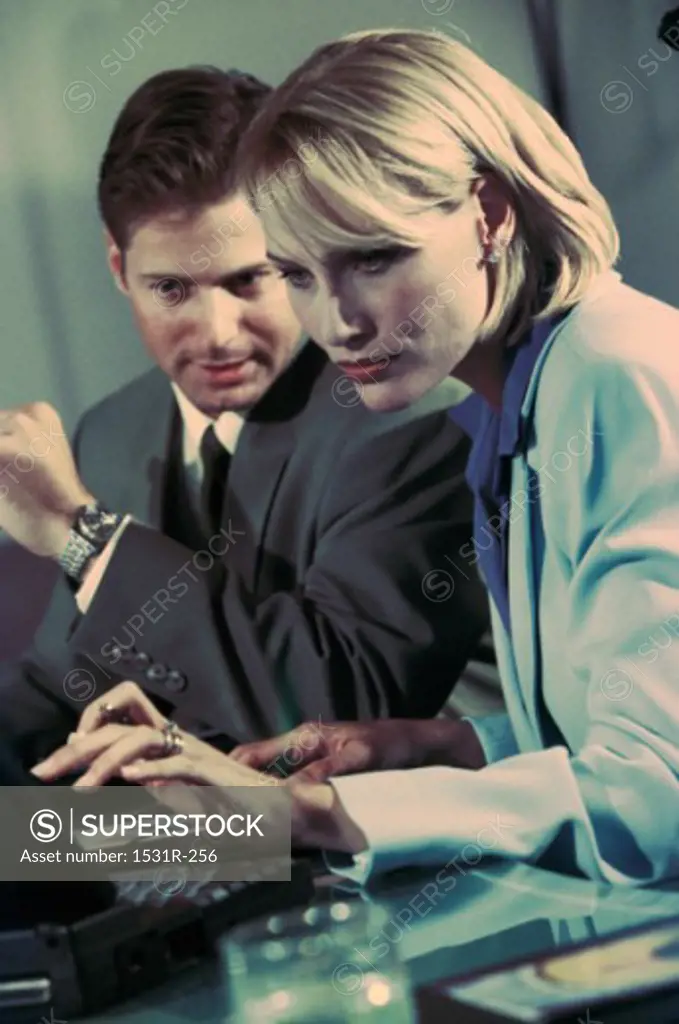 Businessman and a businesswoman working on a laptop