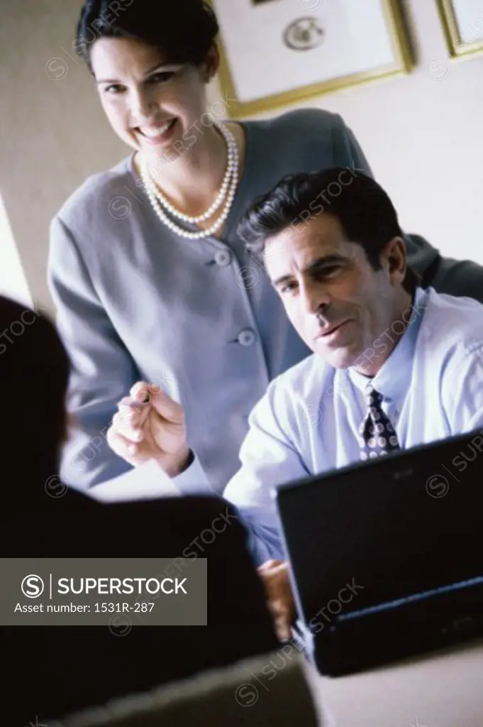 Businessman and a businesswoman smiling in an office