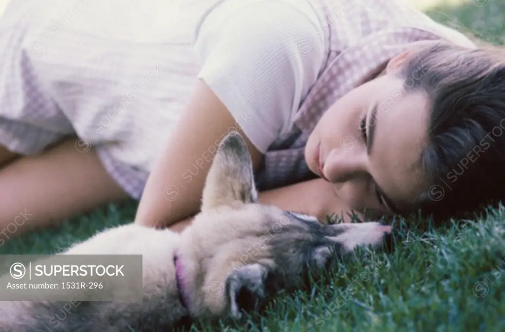 Girl lying on grass with her dog