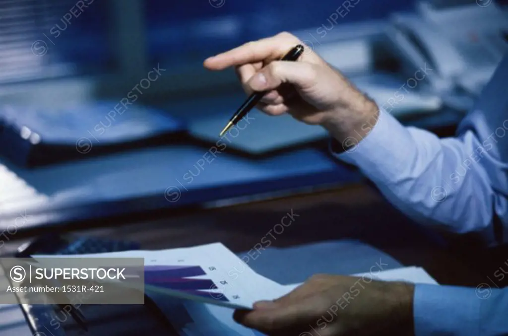Businessman's hand holding a pen pointing forward