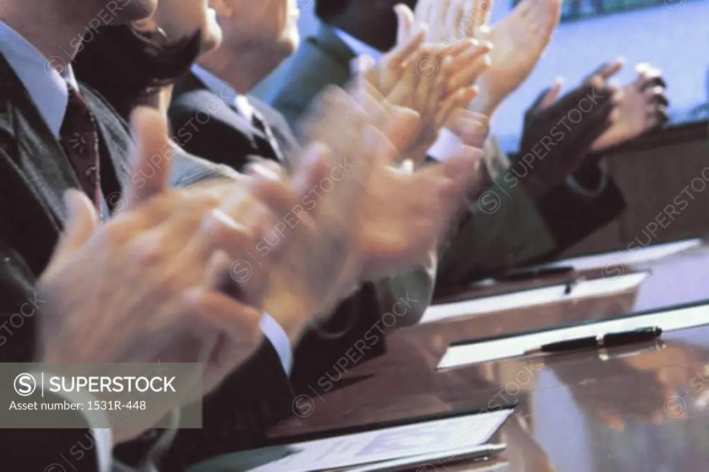 Business executives clapping in an office