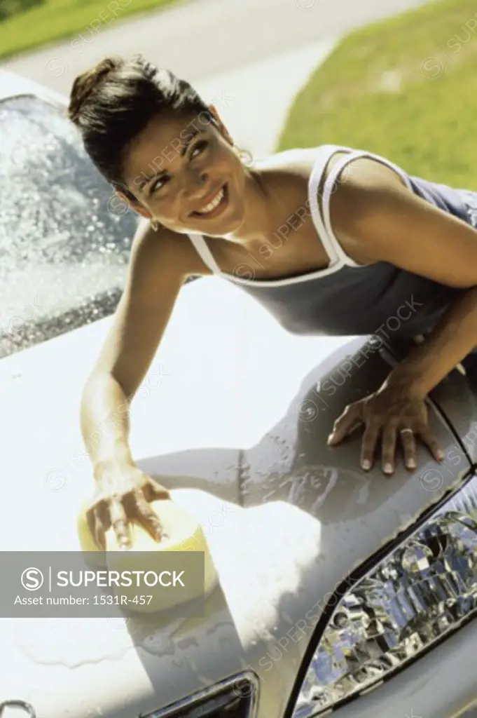 Young woman washing a car